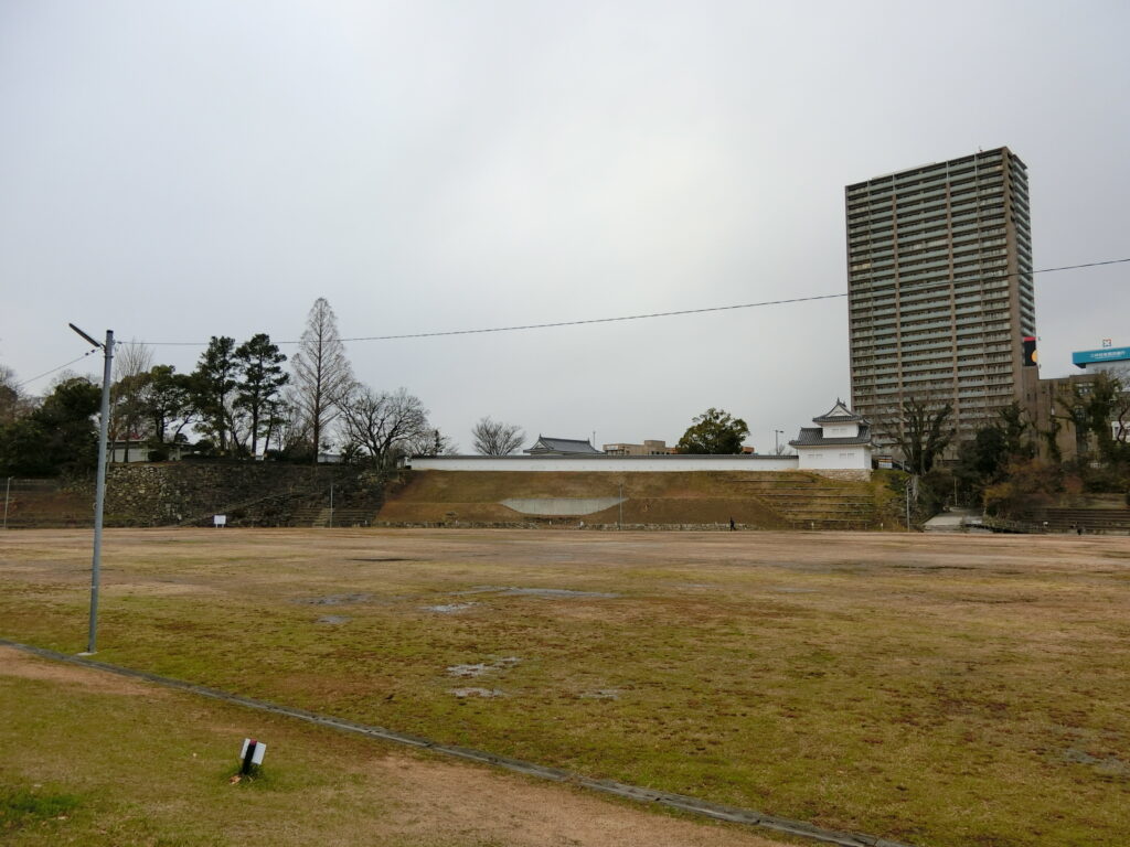 岡崎公園の麓の駐車場から見た東南の「菅生曲輪」（奥の一段上が東曲輪）